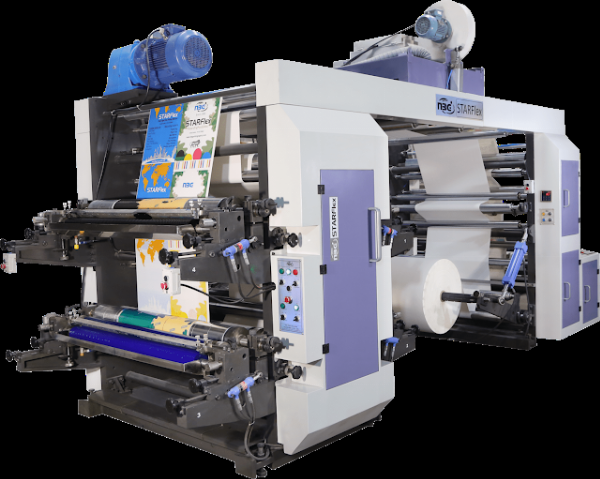 Hình ảnh một máy in offset công nghiệp hiện đại đang hoạt động trong xưởng in, với các cuộn giấy lớn và hệ thống trục lô phức tạp